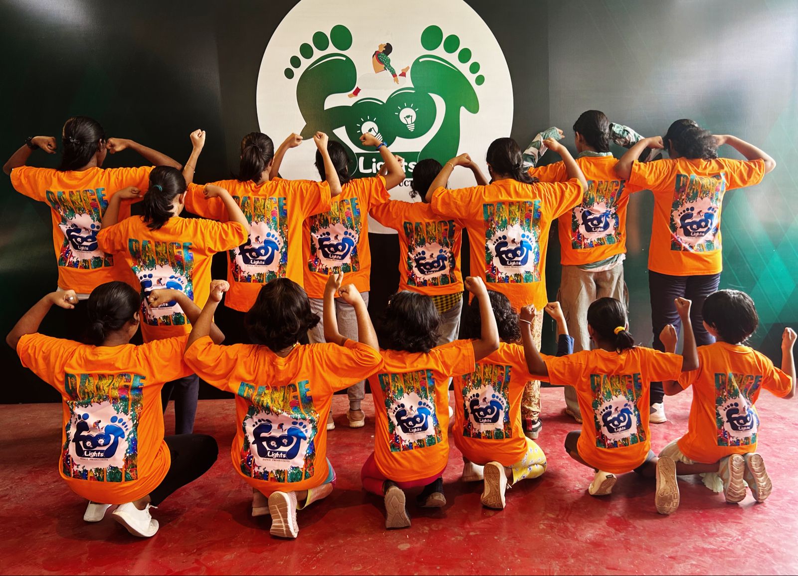 Footlights kids crew posing in front of the Footlights stage backdrop