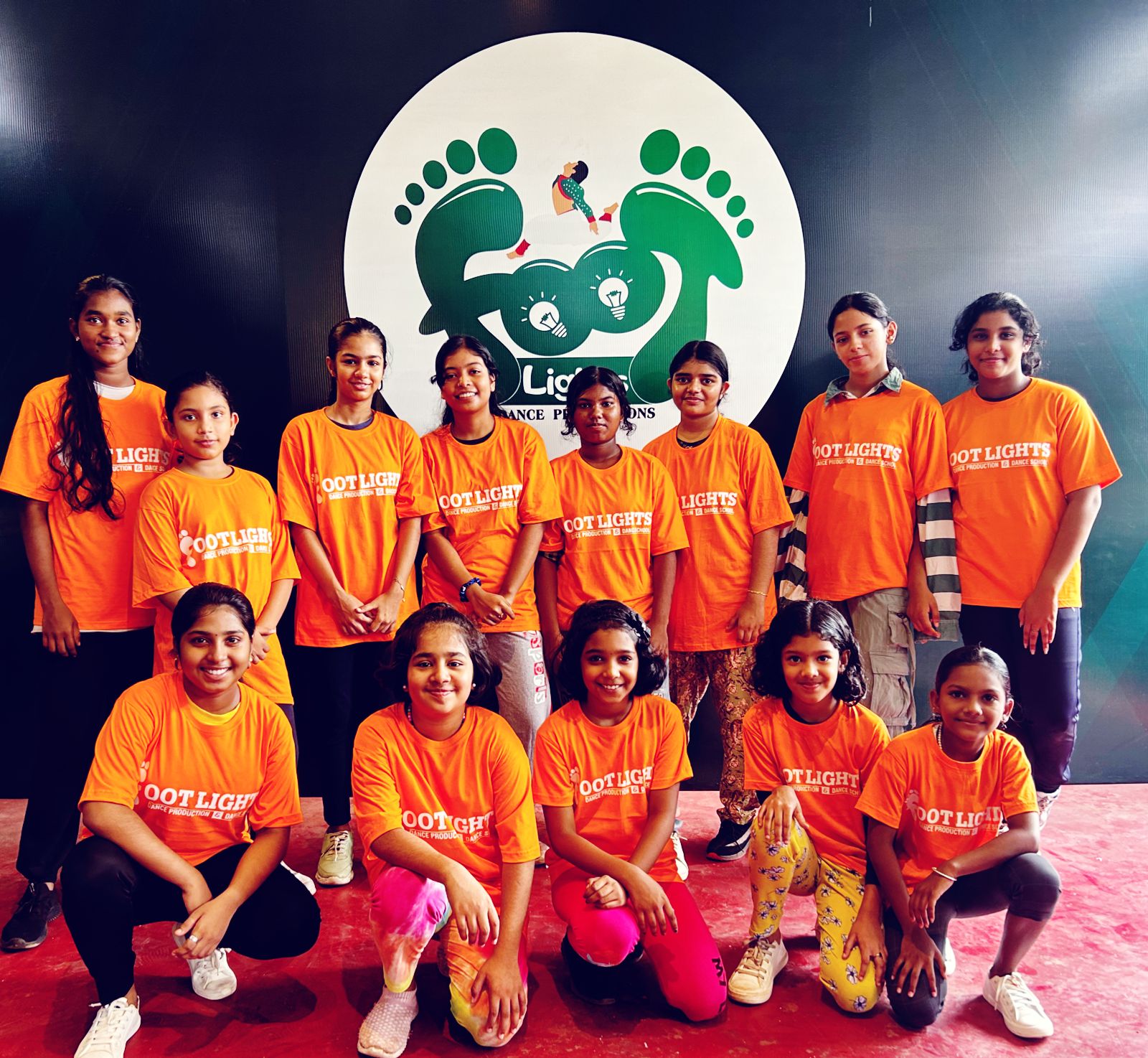 Footlights kids batch in orange team tees on stage in Thrissur